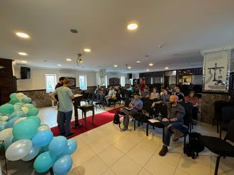 Missions team and local attendees seated in a church for a session decorated with balloons