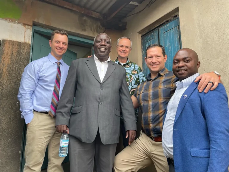 Group of church and ministry leaders smiling outside a local building during a mission visit